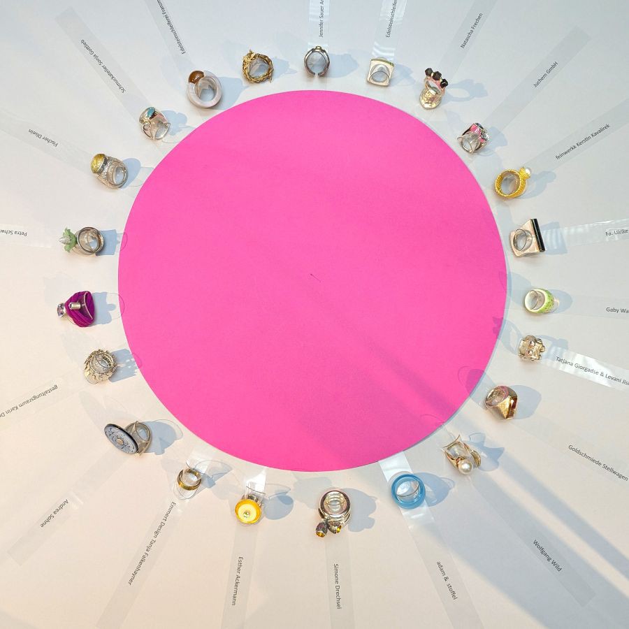 Ringe von 22 Werkstätten kreisförmig um einen großen pinken Kreis auf weißem Untergrund angeordnet mit kleinen Namensschildern