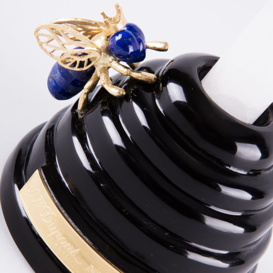 Nahaufnahme eines schwarzen Obsidians in der Form eines Bienenstocks, verziert mit einer gold-blauen Biene, ein Ständer für einen Füllfederhalter aus Bergkristall